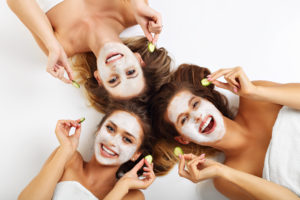 Young ladies laughing while doing facials