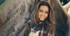Beautiful young woman smiling wearing plaid scarf