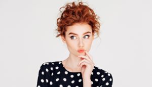 red-headed woman with pensive look