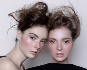 two women with pink cheeks and messy hair